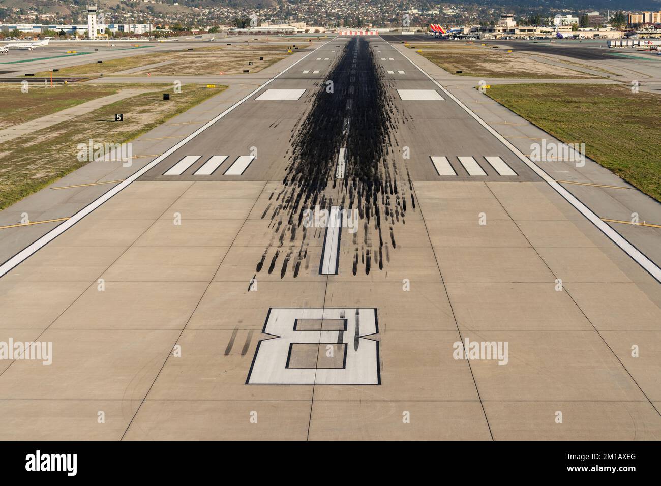 Burbank, Californie, États-Unis - 6 décembre 2022 : marques de dérapage noires sur la piste de l'aéroport de Hollywood Burbank, dans la vallée de San Fernando. Banque D'Images