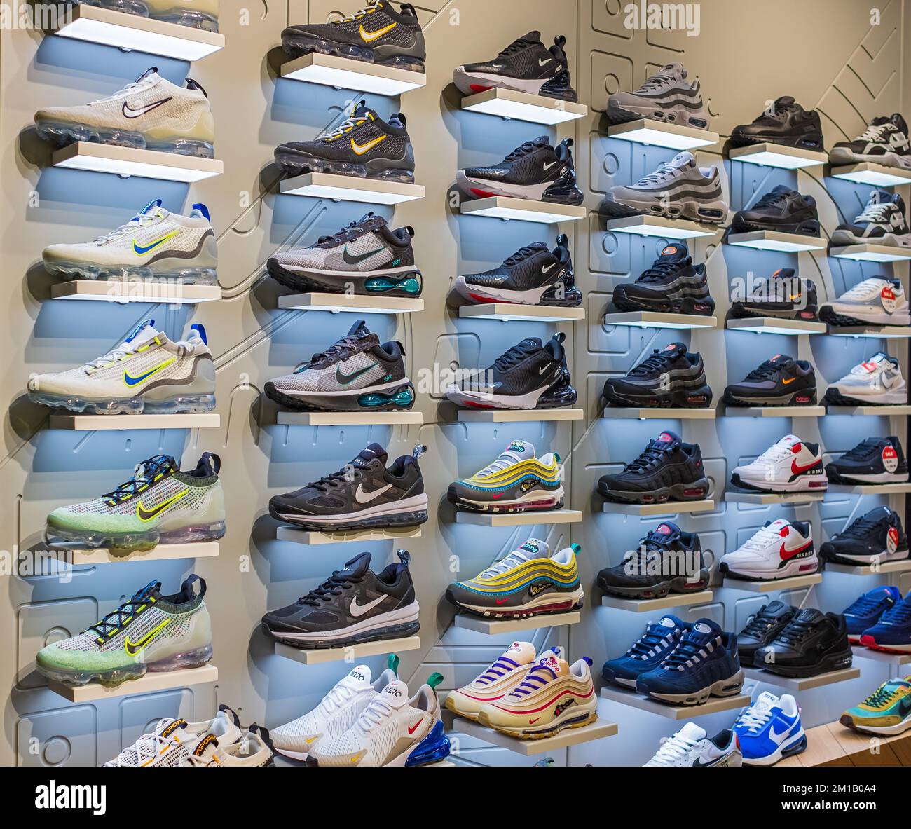 Voir la présentation de nombreuses chaussures de sport sur un mur. Vue sur un mur de chaussures dans la boutique Nike locale. Nouvelles baskets de running modernes et élégantes pour m Banque D'Images