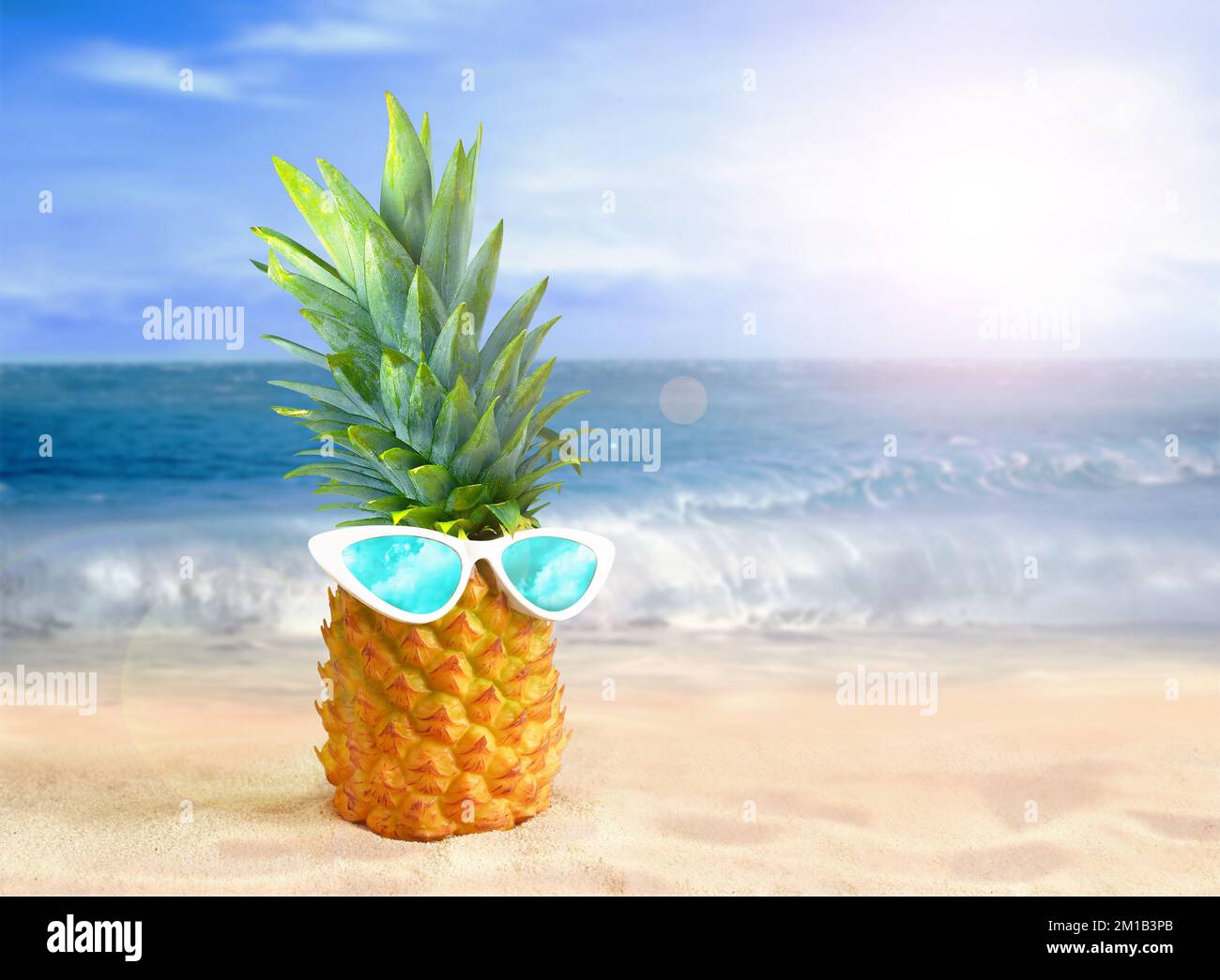Ananas avec lunettes de soleil sur fond de plage tropicale. Concept d'été. Banque D'Images
