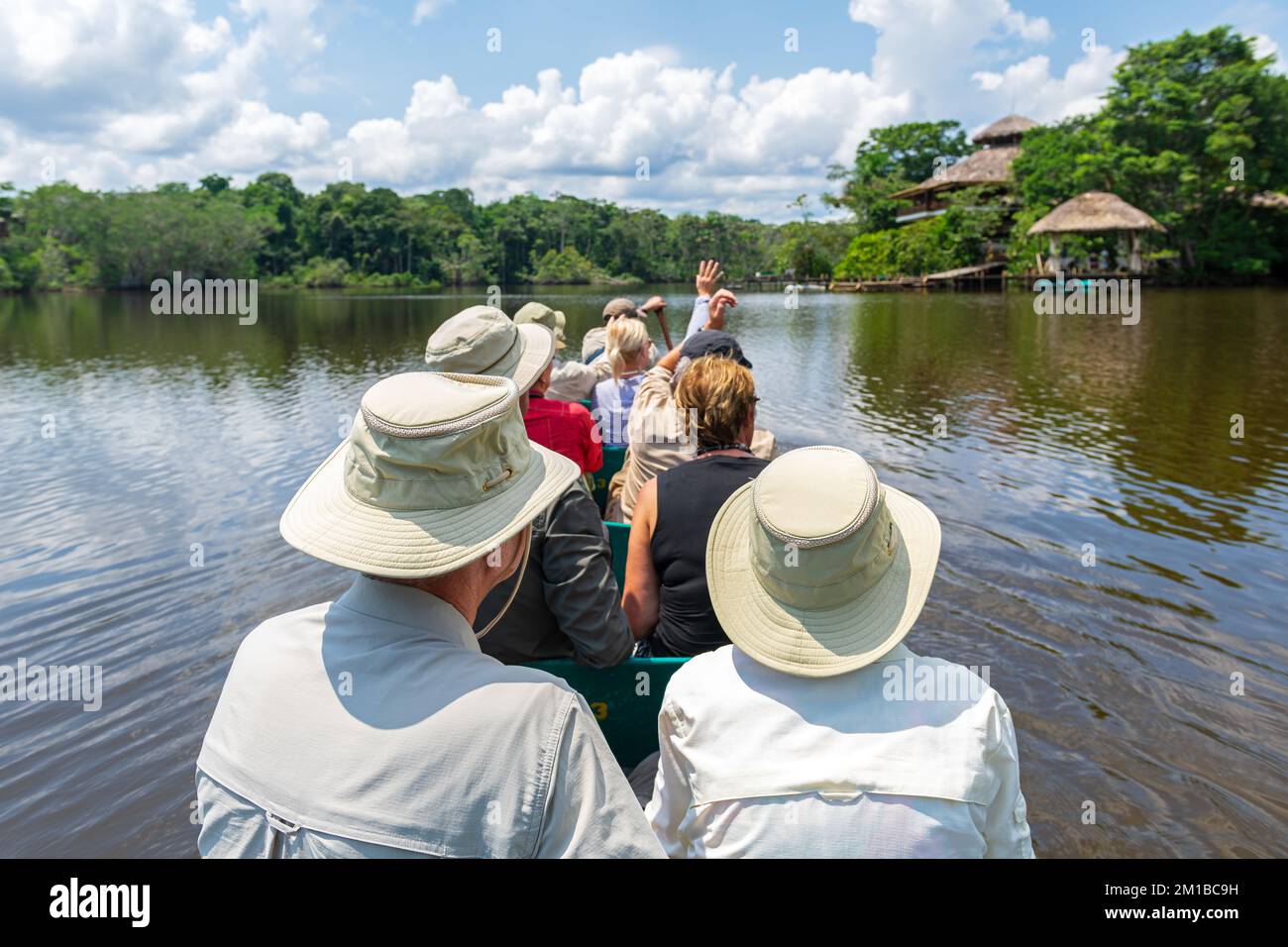 Groupe touristique arrivant au Lodge de la forêt amazonienne en canoë, parc national Yasuni, Équateur. Banque D'Images