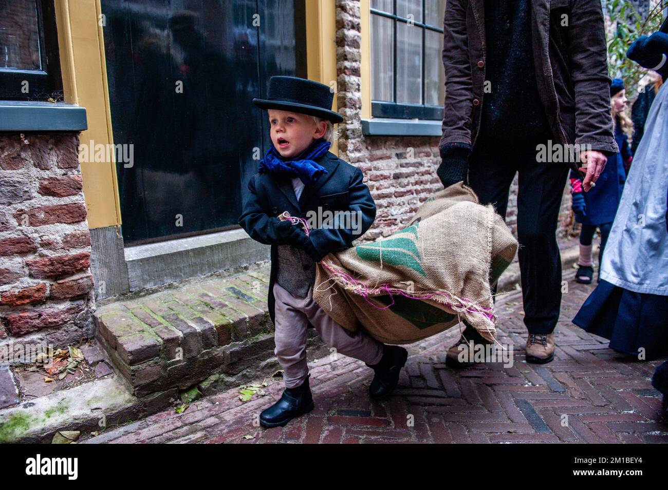Un petit enfant portant des vetements victoriens est vu porter un grand sac pendant le festival. Chaque annee vers cette date le monde du 19th siecle de l ecrivain anglais Charles Dickens revit dans