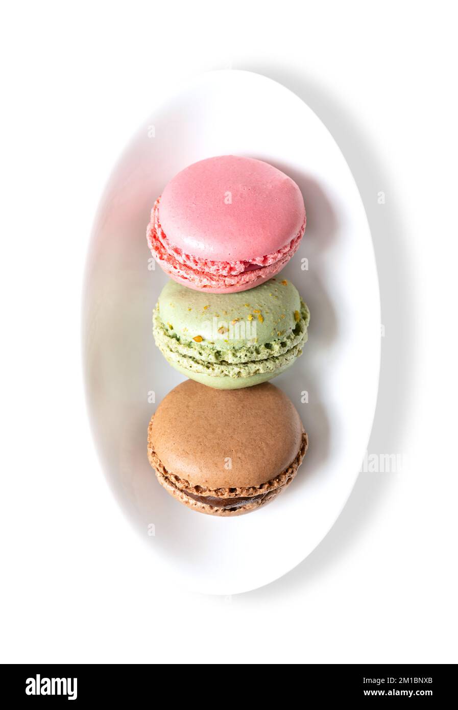 Macarons, macarons français dans un bol blanc. Confiseries sucrées à base de meringue, de style parisien, à base de blanc d'œuf, de sucre, d'amandes et de colorants alimentaires. Banque D'Images
