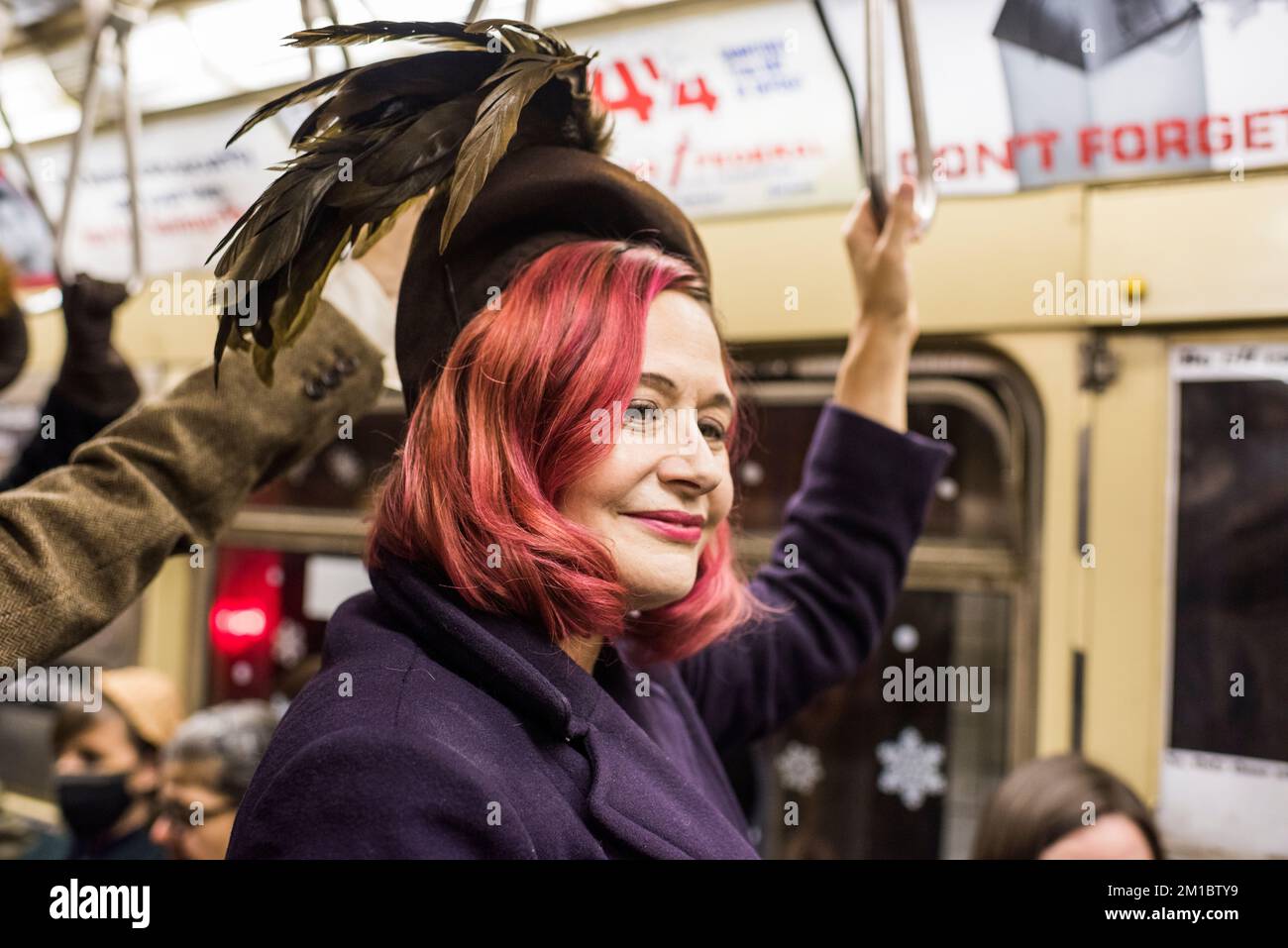 New York, New York - 11 décembre 2022: Les gens dans les vêtements d'époque à cheval sur le train de nombreuses couleurs, vacances nostalgie manèges, NYC Banque D'Images