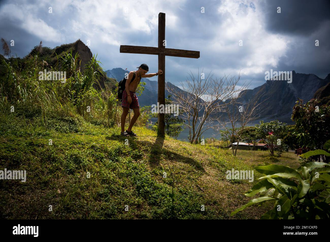 Un touriste se tient à la croix du mémorial au sommet du mont Pinatubo, qui a éclaté en 1991 et a tué des milliers de personnes Banque D'Images