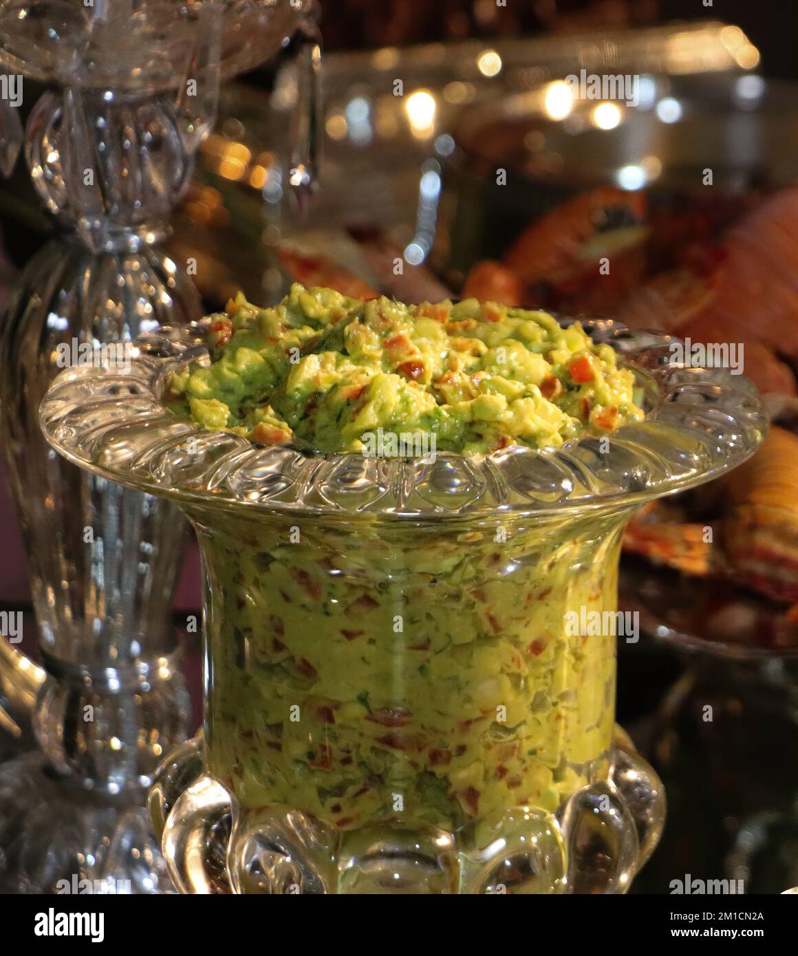 Guacamole mexicaine, dans un bol en verre sur une table de fête Banque D'Images