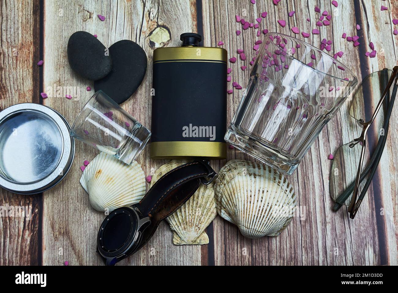 tirer des coquillages de la fiole de verre et un verre à boire smart watch verres sur le bois Banque D'Images