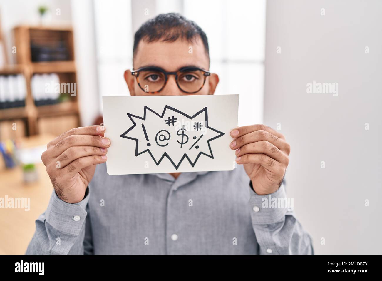 Homme du Moyen-Orient avec la barbe tenant la bannière avec jurons mots sans indice et expression confuse. notion de doute. Banque D'Images