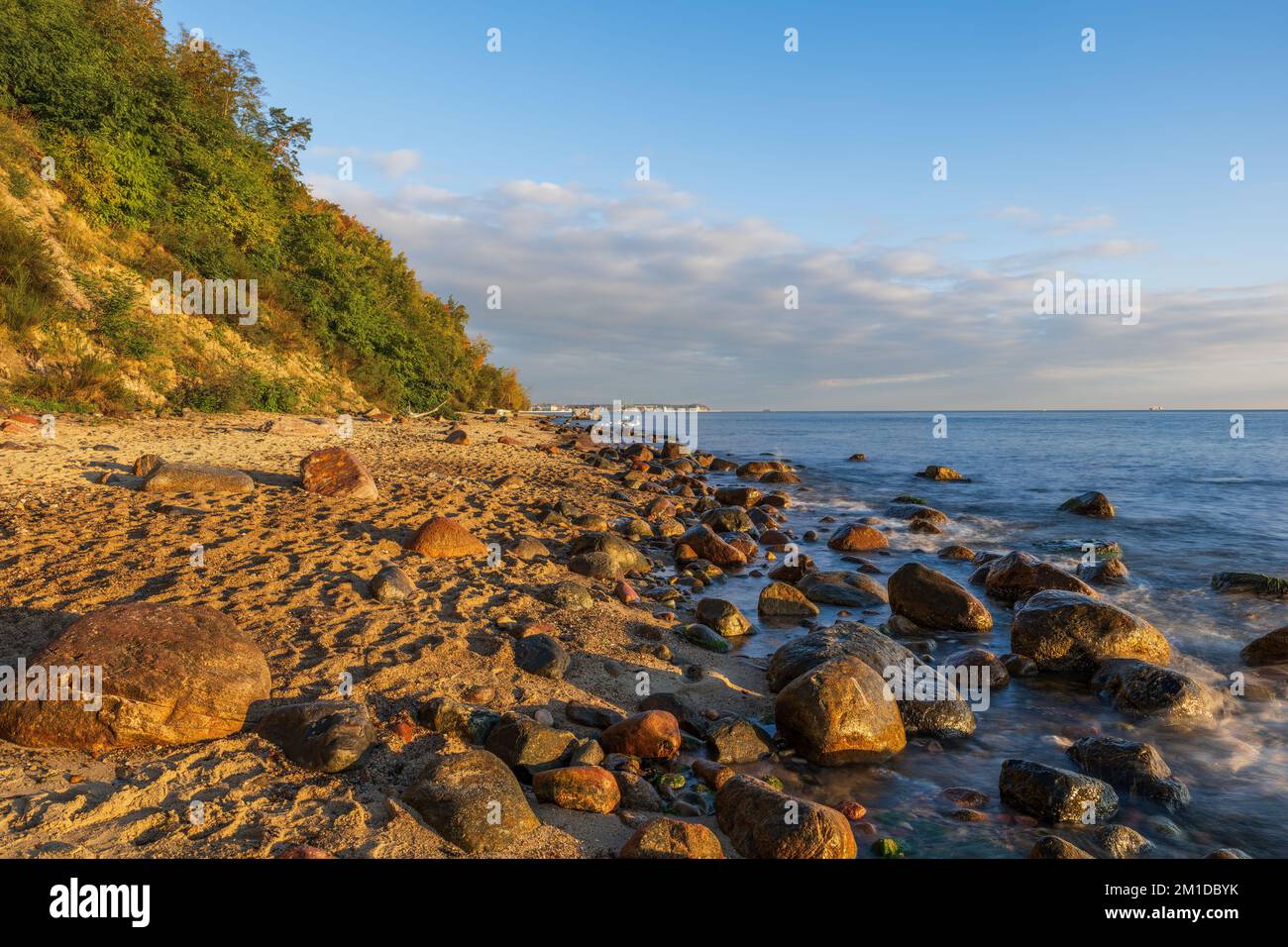 Plage de sable avec rochers sur la mer Baltique au lever du soleil à Gdynia, Pologne. Banque D'Images