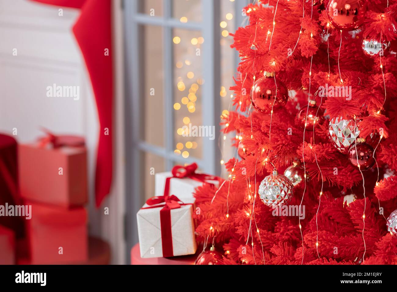 Intérieur de Noël élégant avec un sapin de noël rouge et des boîtes de cadeaux. Confort à la maison. Banque D'Images