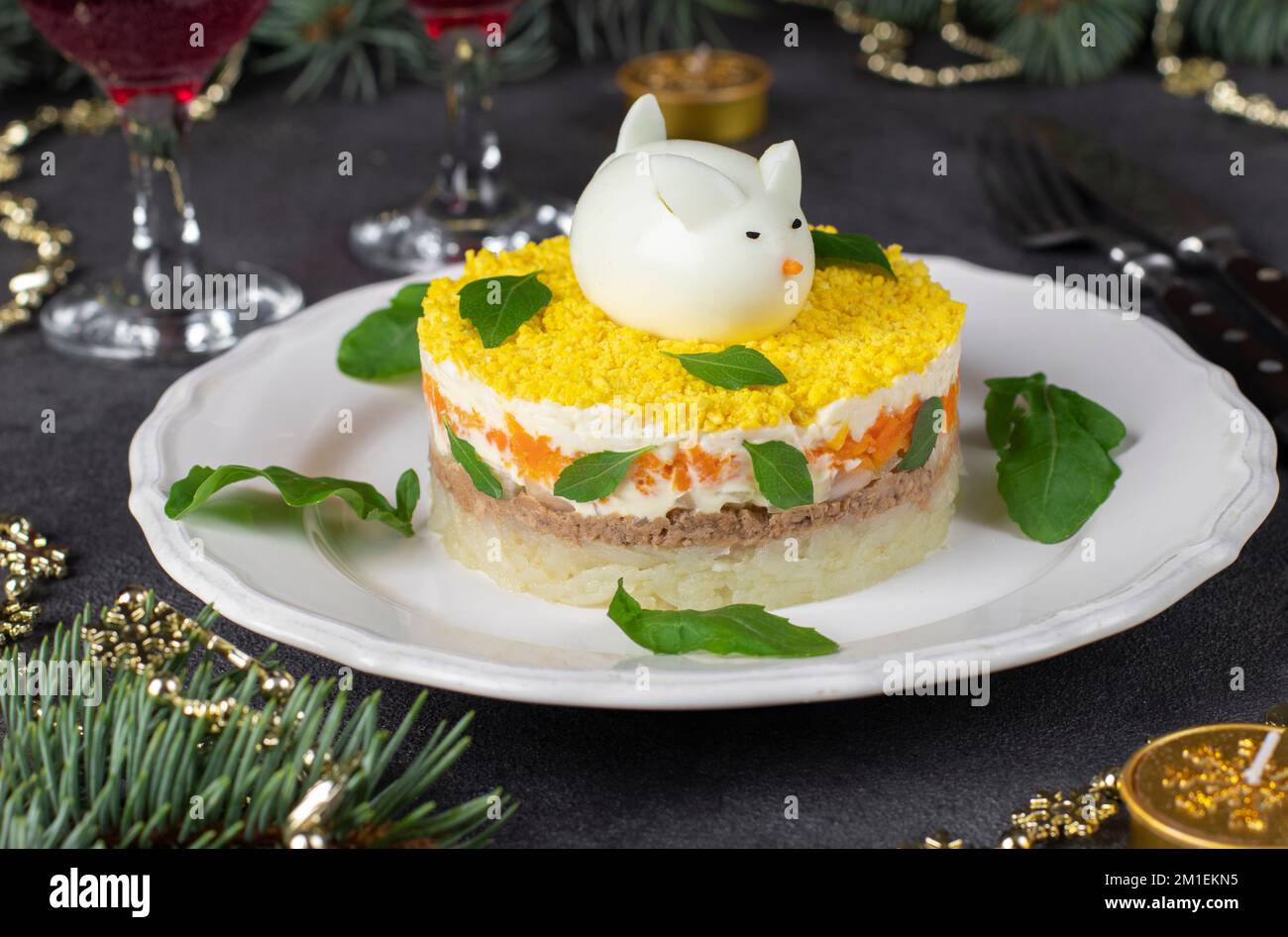 Salade feuilletée Mimosa pour le nouvel an avec thon en conserve, pommes de terre et carottes, lapin décoré d'œufs Banque D'Images