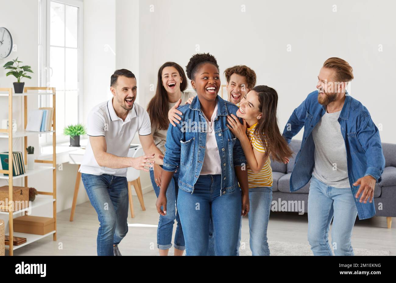 Bonne jeune femme afro-américaine s'amusant avec ses amis lors d'une fête à la maison Banque D'Images