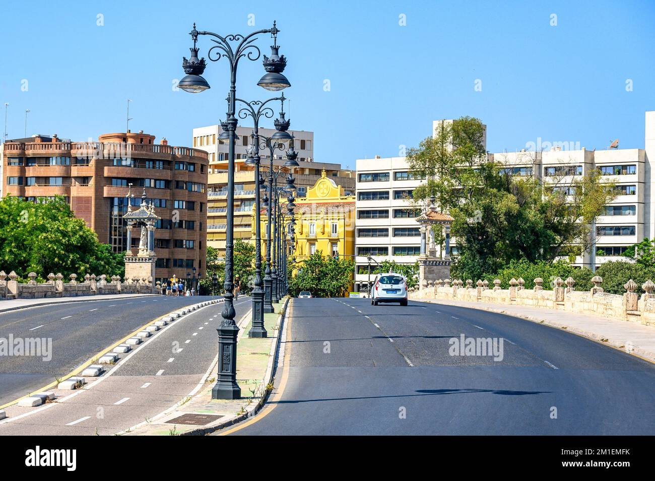 Valence, Espagne - 16 juillet 2022: Une avenue de ville bordée de lampes électriques anciennes. Banque D'Images