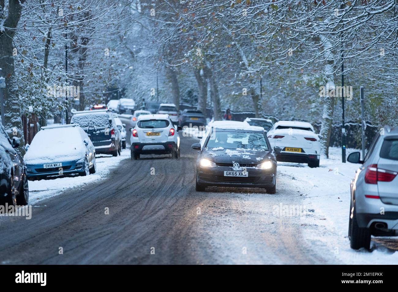 Londres , Royaume-Uni . La circulation est visible à travers la neige dans Queens Park, West London les navetteurs à travers Londres sont confrontés à un défi pour se rendre au travail Banque D'Images