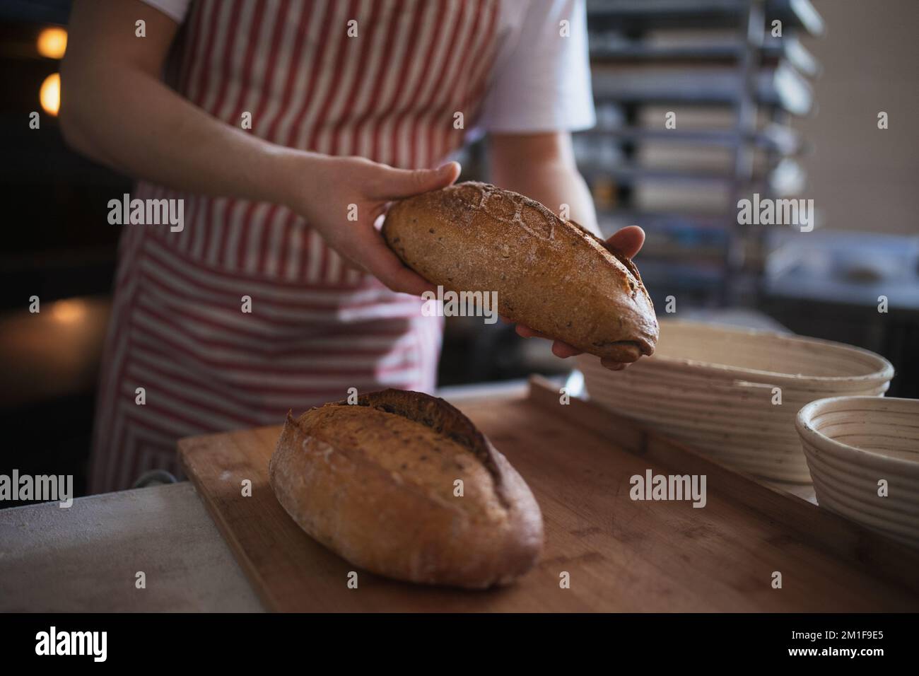 Gros plan du boulanger avec du pain frais dans la boulangerie. Banque D'Images