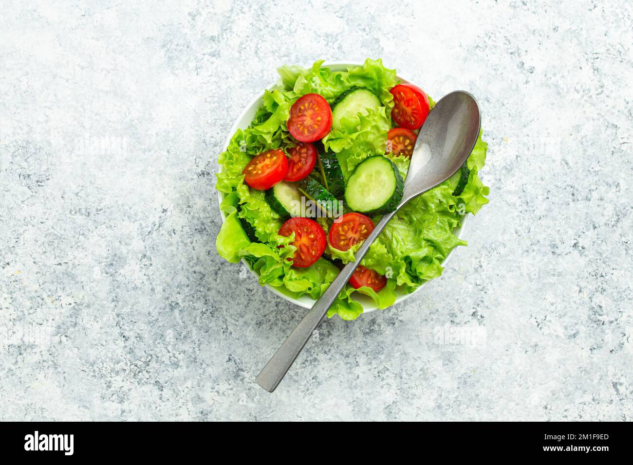 Tomates saines concombres iceberg laisse la salade sur table blanche vue du dessus Banque D'Images