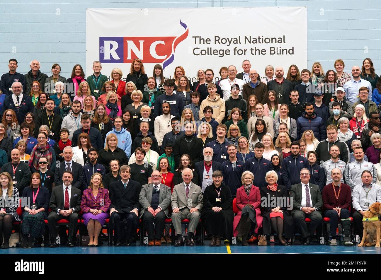 Le roi Charles III (centre inférieur) ayant une photo prise avec des étudiants, du personnel et des bénévoles lors de sa visite au Collège national royal pour les aveugles (RNC) à Hereford. Date de la photo: Lundi 12 décembre 2022. Banque D'Images