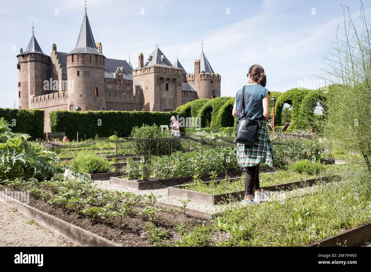 Les visiteurs visitent les jardins du 17th siècle dans les remparts du château de Muiderslot à Muiden, pays-Bas. Banque D'Images