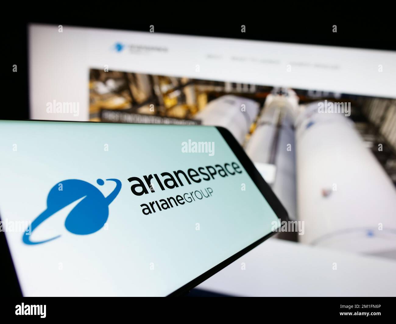 Smartphone avec logo de la société aérospatiale française Arianespace SAS sur écran en face du site Web des entreprises. Mise au point au centre-gauche de l'écran du téléphone. Banque D'Images