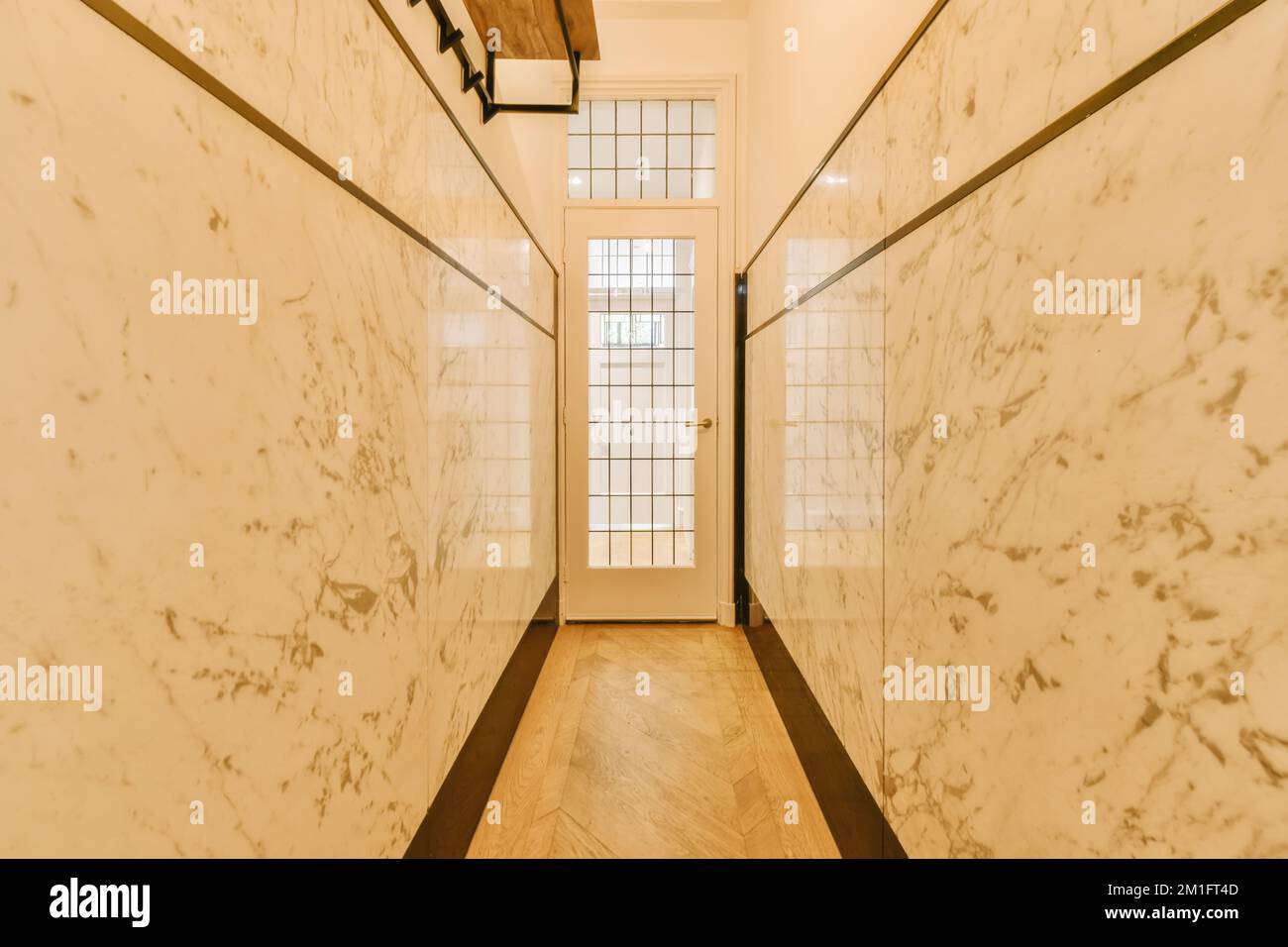 un long couloir avec du marbre blanc sur les murs et des boiseries autour du mur pour lui donner l'apparence d'un art déco Banque D'Images