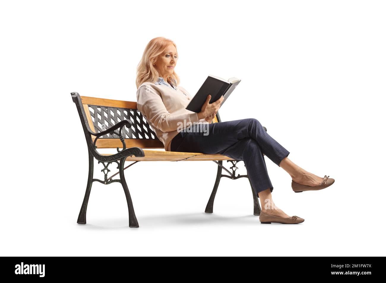 Femme mature assise sur un banc et lisant un livre isolé sur fond blanc Banque D'Images