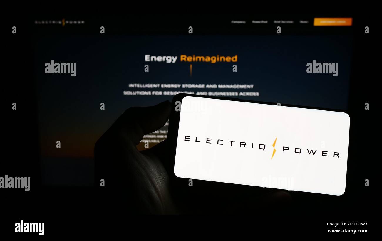 Personne tenant un téléphone portable avec le logo de la société américaine de stockage d'énergie Electriq Power Inc. À l'écran devant la page Web. Mise au point sur l'affichage du téléphone. Banque D'Images