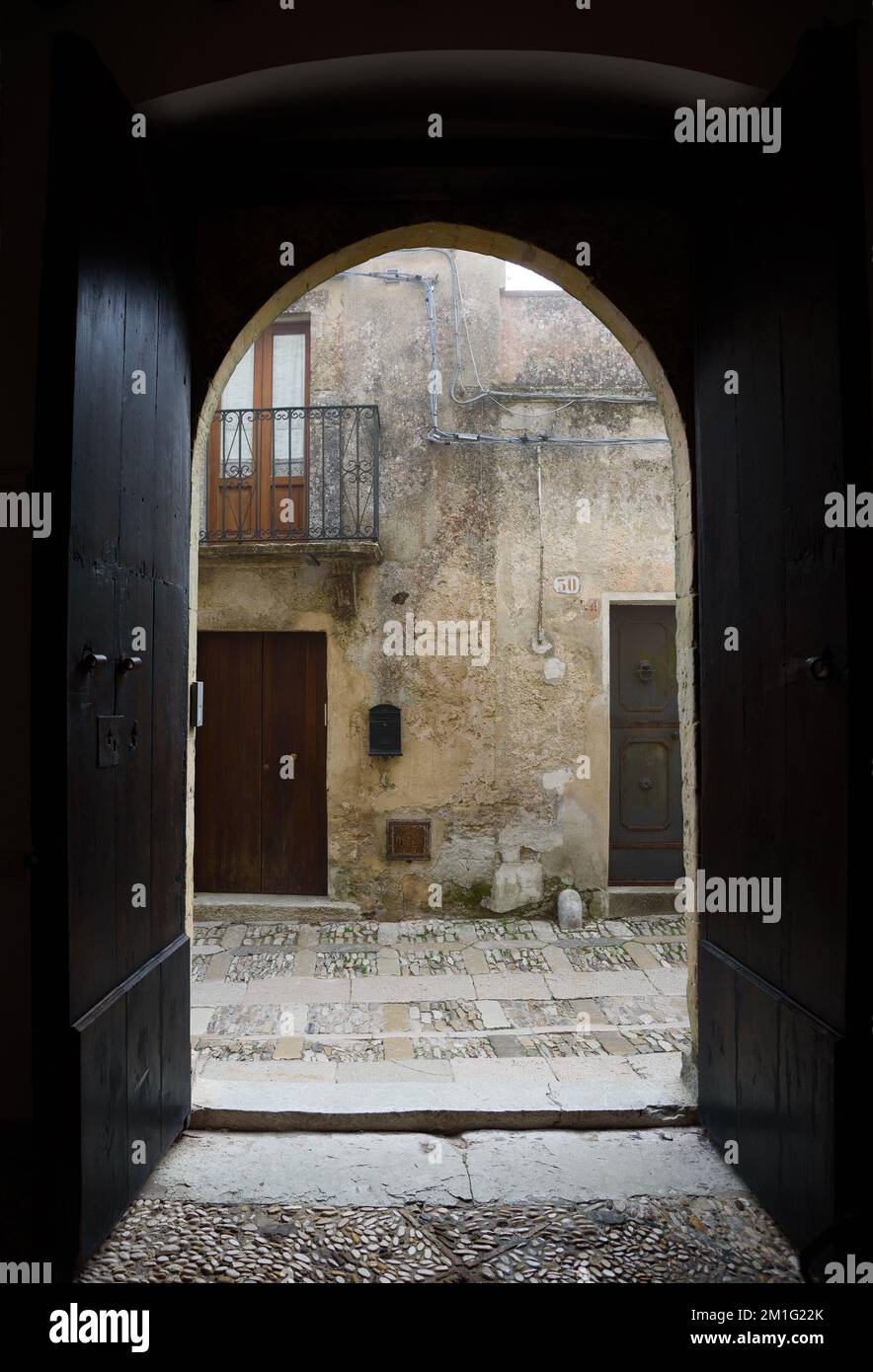 Vue sur la rue par une porte voûtée à Erice. Banque D'Images Vue sur la rue par une porte voûtée à Erice. Banque D'Images