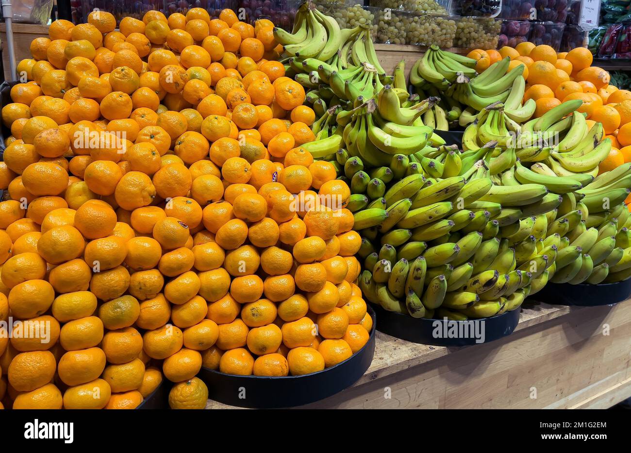 Porte-fruits de supermarché. Fruits à la mandarine et à la banane verte dans l'épicier. Vue latérale Banque D'Images