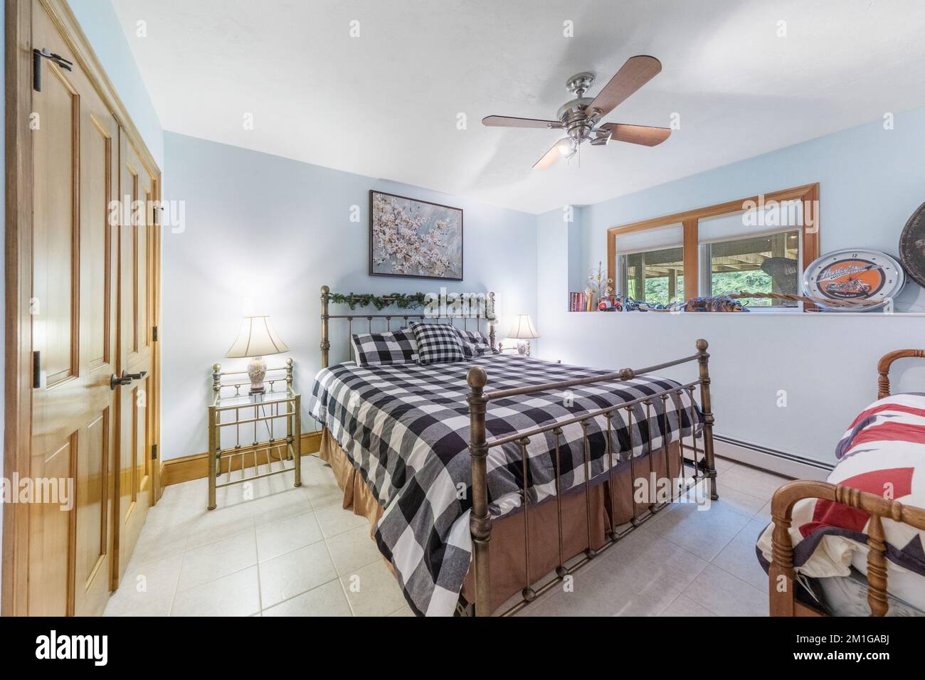Vue intérieure d'une chambre avec ventilateur de plafond et murs bleu clair. Banque D'Images