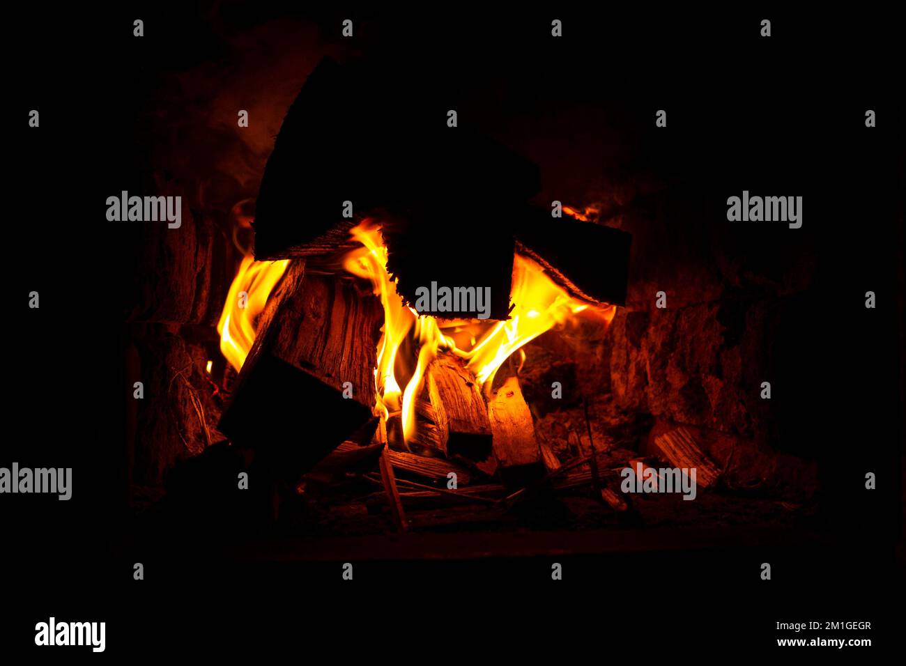 bois de chauffage brûlant dans le four fermé, chaleur confortable près de la cheminée. Banque D'Images