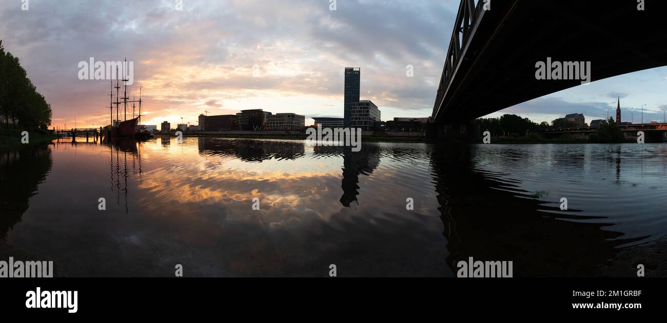 Coucher de soleil sur la rivière Weser à Brême avec le reflet des bureaux de l'Überseestadt Banque D'Images