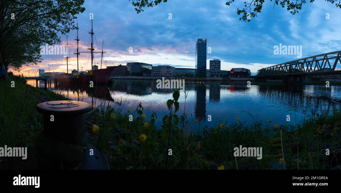 Coucher de soleil sur la rivière Weser à Brême avec le reflet des bureaux de l'Überseestadt Banque D'Images