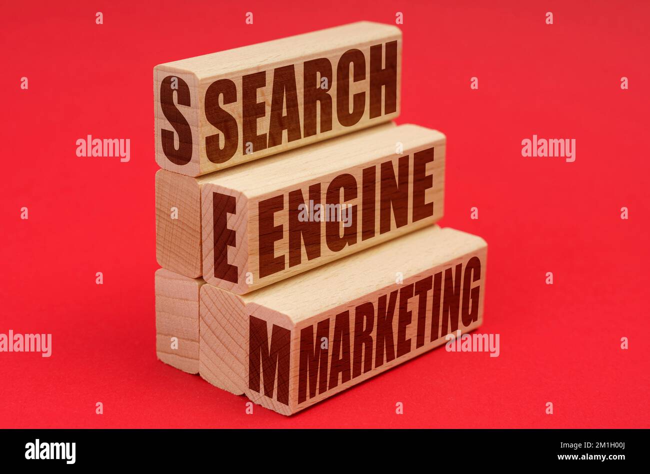Concept d'affaires et d'économie. Sur fond rouge, blocs de bois avec l'inscription - Search Engine Marketing Banque D'Images