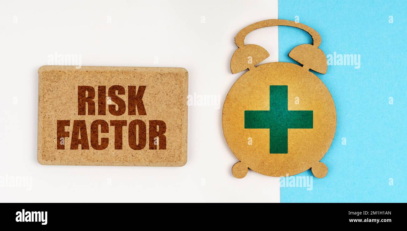 Médecine et concept de santé. Sur la surface blanche et bleue se trouvent un réveil et un signe avec l'inscription - FACTEUR DE RISQUE Banque D'Images