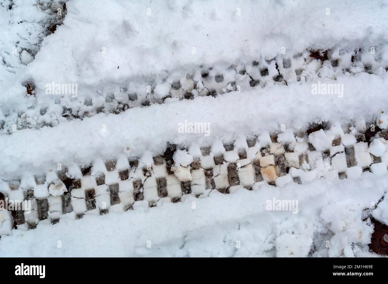 Pistes de pneus à partir d'un quad et d'une moto dans la neige fraîche à Rollestone Wood, dans la vallée de Gleadless, Sheffield, Royaume-Uni. Banque D'Images