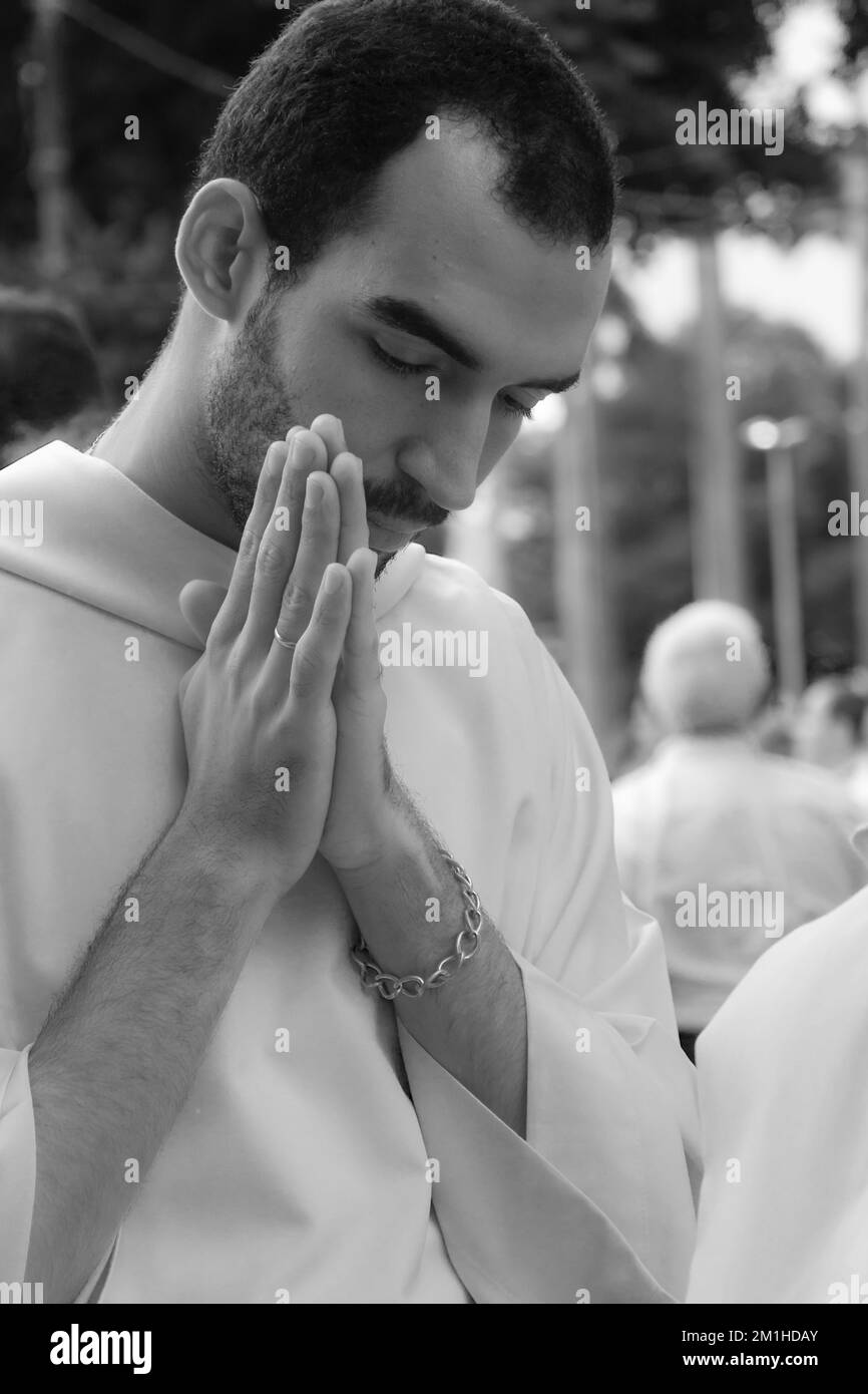 Salvador, Bahia, Brésil - 25 mai 2016 : un jeune prêtre prie pendant la procession du Corpus Christ à Salvador, Bahia. Banque D'Images