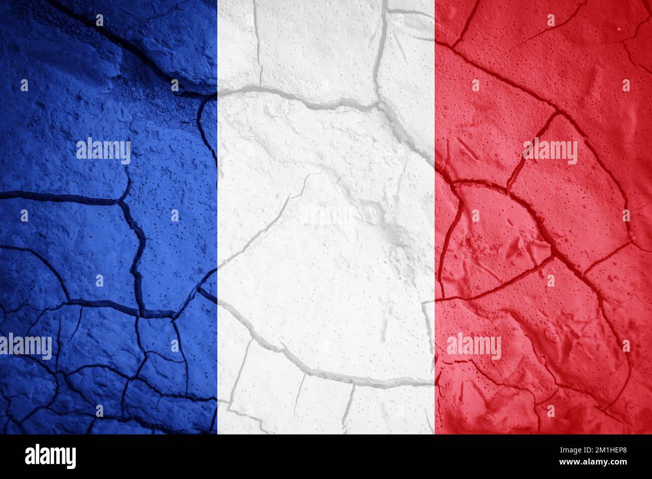 Drapeau de la France. Symbole français. Drapeau sur fond de terre sèche fissurée. Concept de drapeau français avec sécheresse Banque D'Images