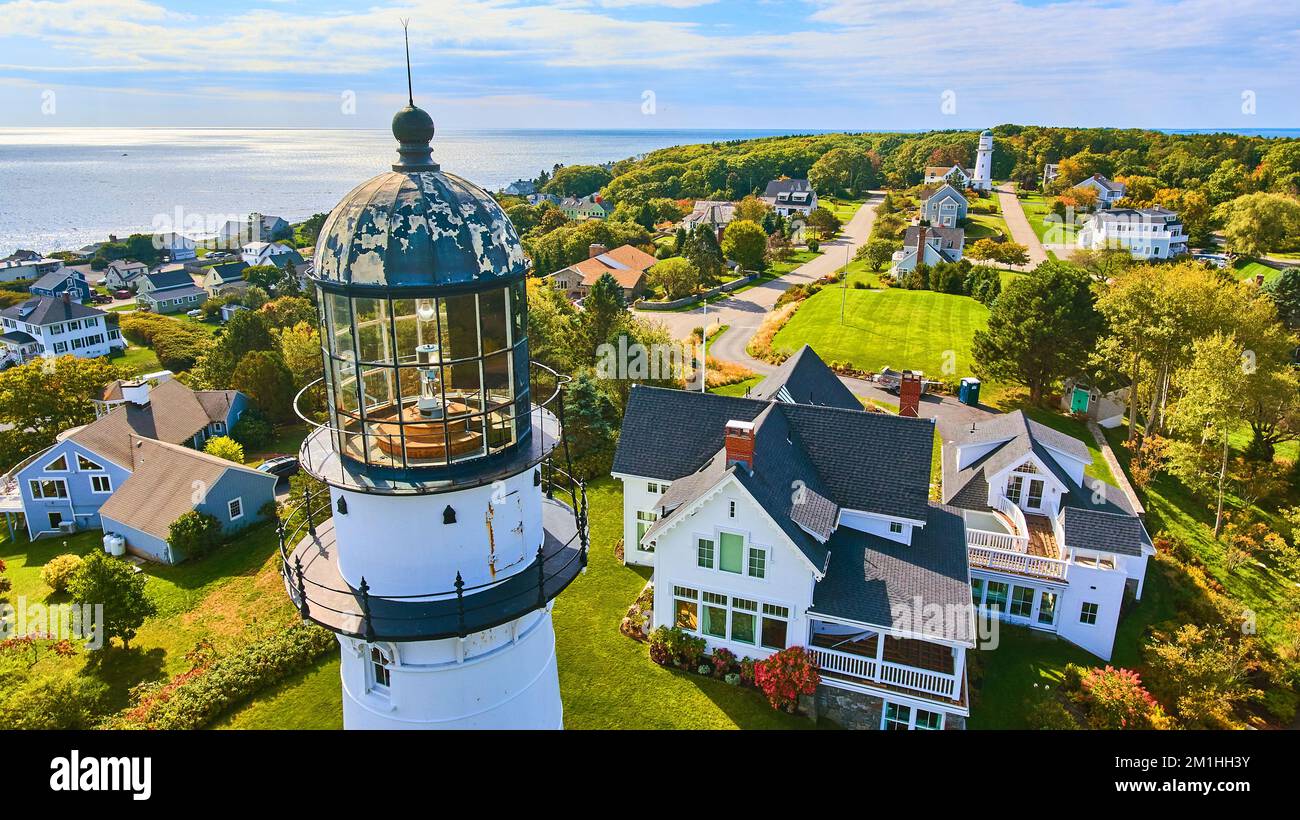 En haut de l'antenne de près au sommet du phare blanc avec les maisons et vue sur l'océan dans le Maine Banque D'Images