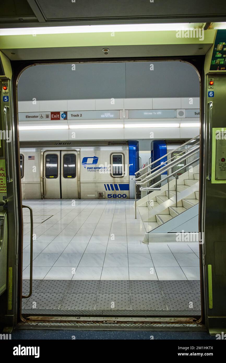 Métro de New York donnant sur les portes de la gare moderne et propre avec train de l'autre côté des escaliers Banque D'Images