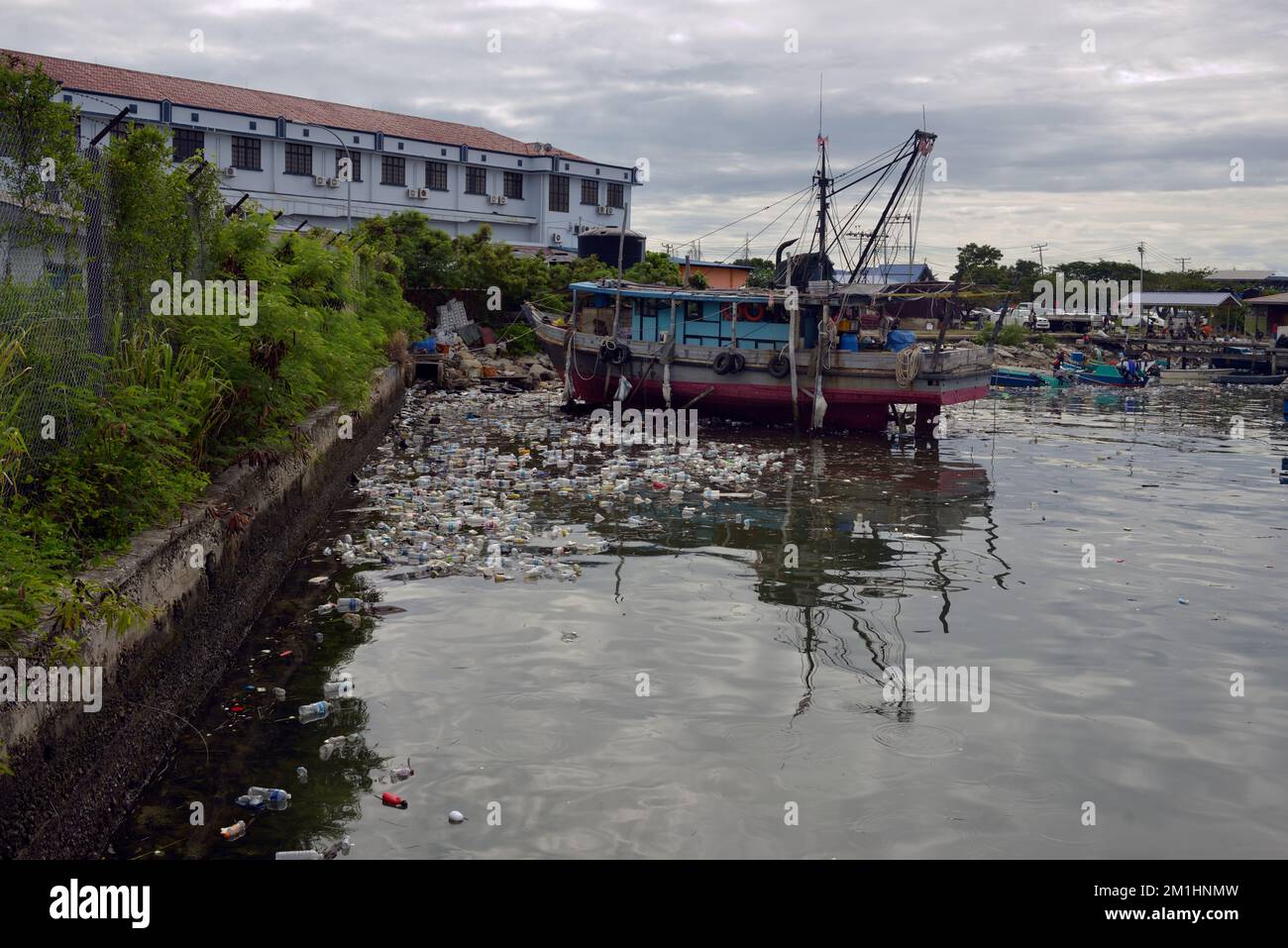 Les bouteilles en plastique jetées polluent le port et menacent l'industrie locale de la pêche à Kudat, Bornéo, en Malaisie. Banque D'Images