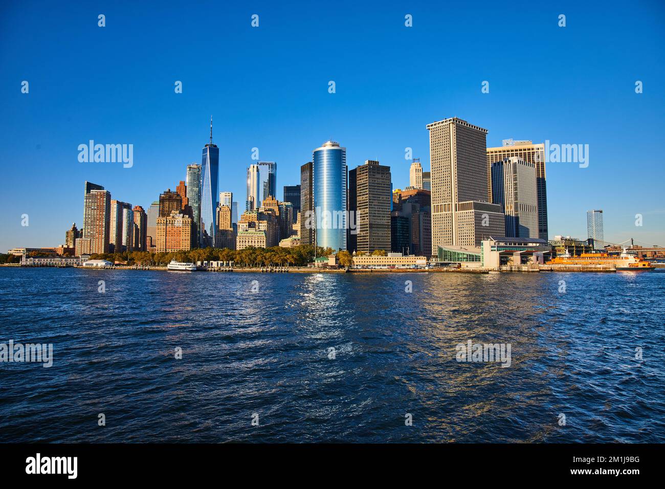 Magnifique horizon de New York depuis l'eau avec lumière du soleil frappant le sud de Manhattan Banque D'Images