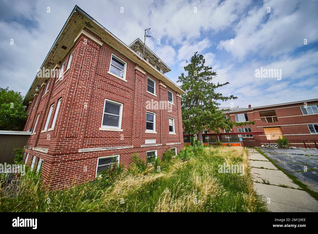 Bâtiments en briques abandonnés de trois étages avec champs surcultivés Banque D'Images