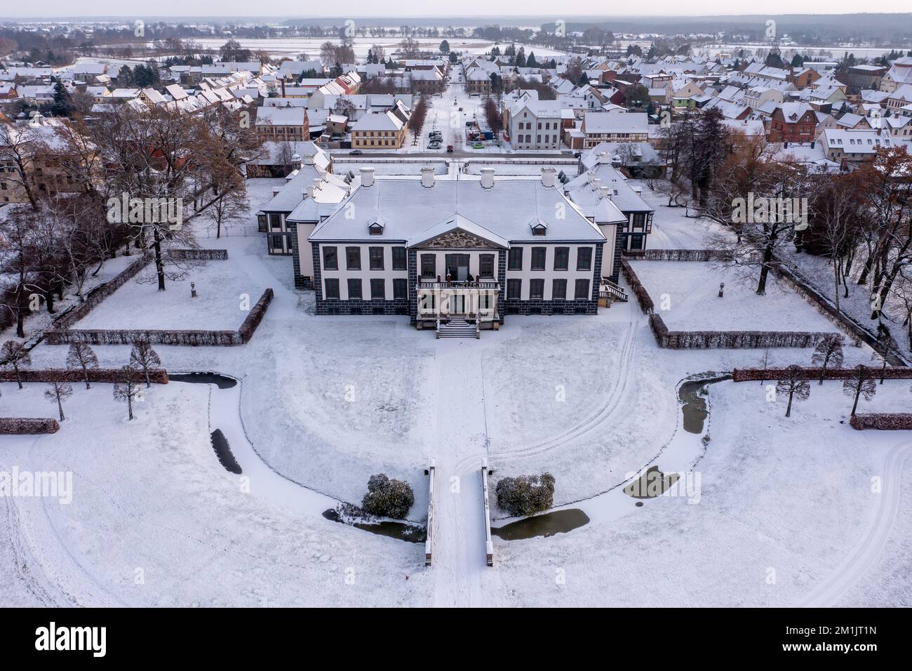 Oranienbaum, Allemagne. 12th décembre 2022. Les passants marchent à pied dans le parc enneigé du château d'Oranienbaum. Construit en 1683 comme résidence d'été pour la princesse Henriette Catharina, épouse du prince Johann Georg II d'Anhalt-Dessau et princesse d'Orange-Nassau de naissance, le palais a été restauré morceau par morceau depuis des années. Avec son magnifique jardin, il fait partie du Royaume des jardins de Dessau-Wörlitz, site classé au patrimoine mondial de l'UNESCO. (Vue aérienne avec drone) Credit: Jan Woitas/dpa/Alamy Live News Banque D'Images