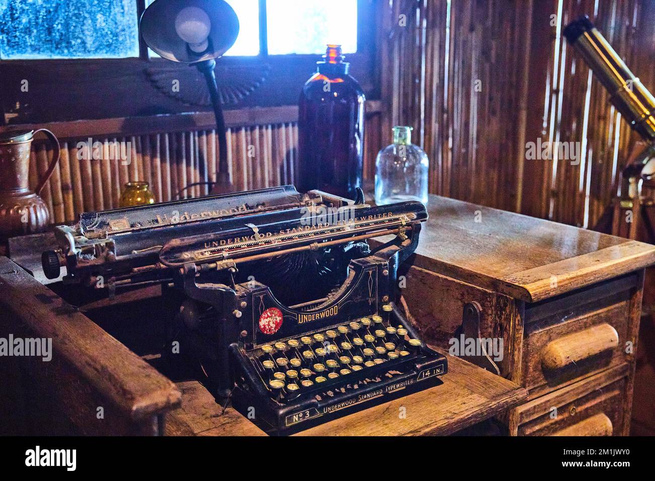 Scène de la vie de vieille machine à écrire sur vieux bureau en bois avec des objets anciens comme des bouteilles autour Banque D'Images