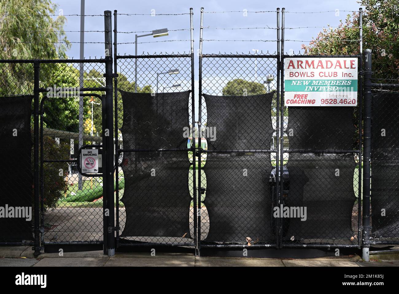 Entrée ouest du club de boules Armadale, sur Nelson St, avec panneaux, escrime noire et barbelés Banque D'Images