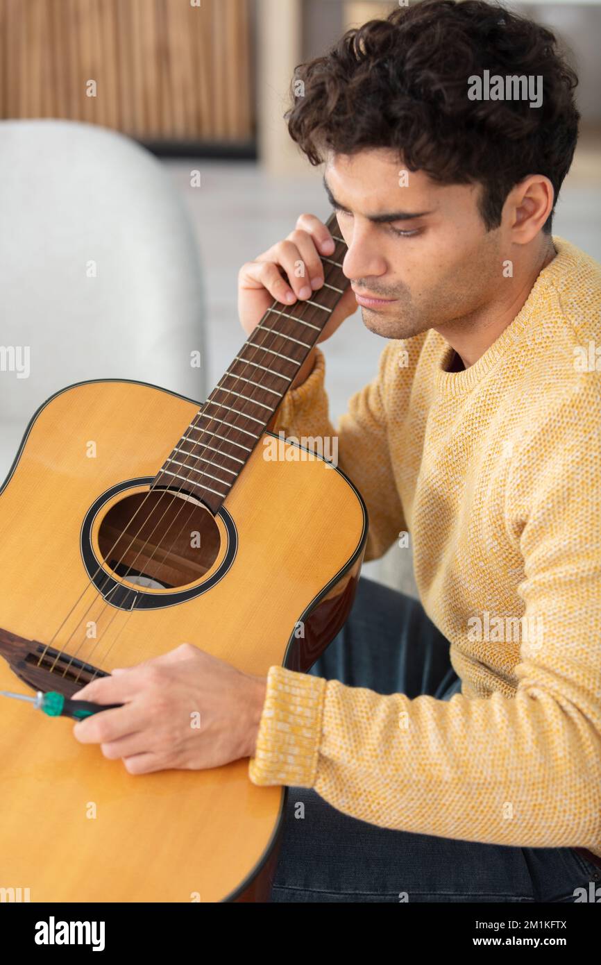 Luthier magasin et instruments de musique acoustique : un jeune adulte  artisan corrige un vieux classique de la guitare, puis le stocke dans une  boîte en carton Photo Stock - Alamy