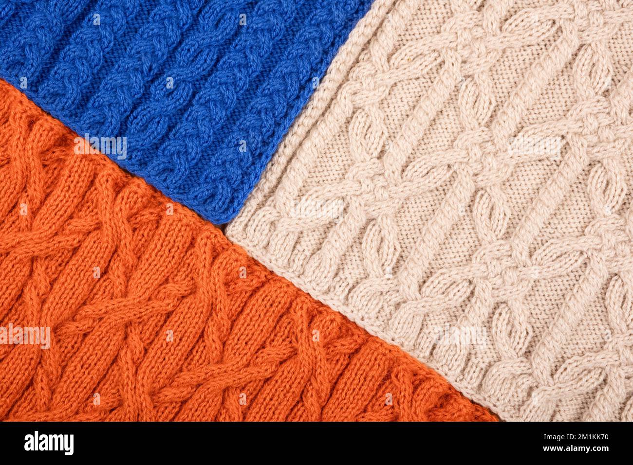 Fond bleu orange et beige. Grand tissu tricoté avec un motif. Gros plan d'une couverture tricotée. Banque D'Images