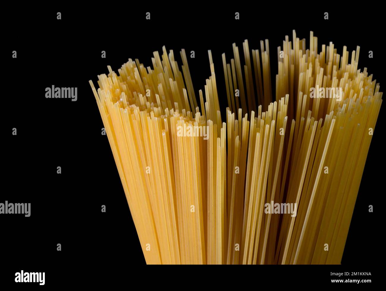 Spaghetti longs jaunes sur fond noir. Pâtes fines disposées en rangées. Pâtes italiennes jaunes. Spaghetti longs. Spaghetti bolognaise cru. Spaghetti crus Banque D'Images