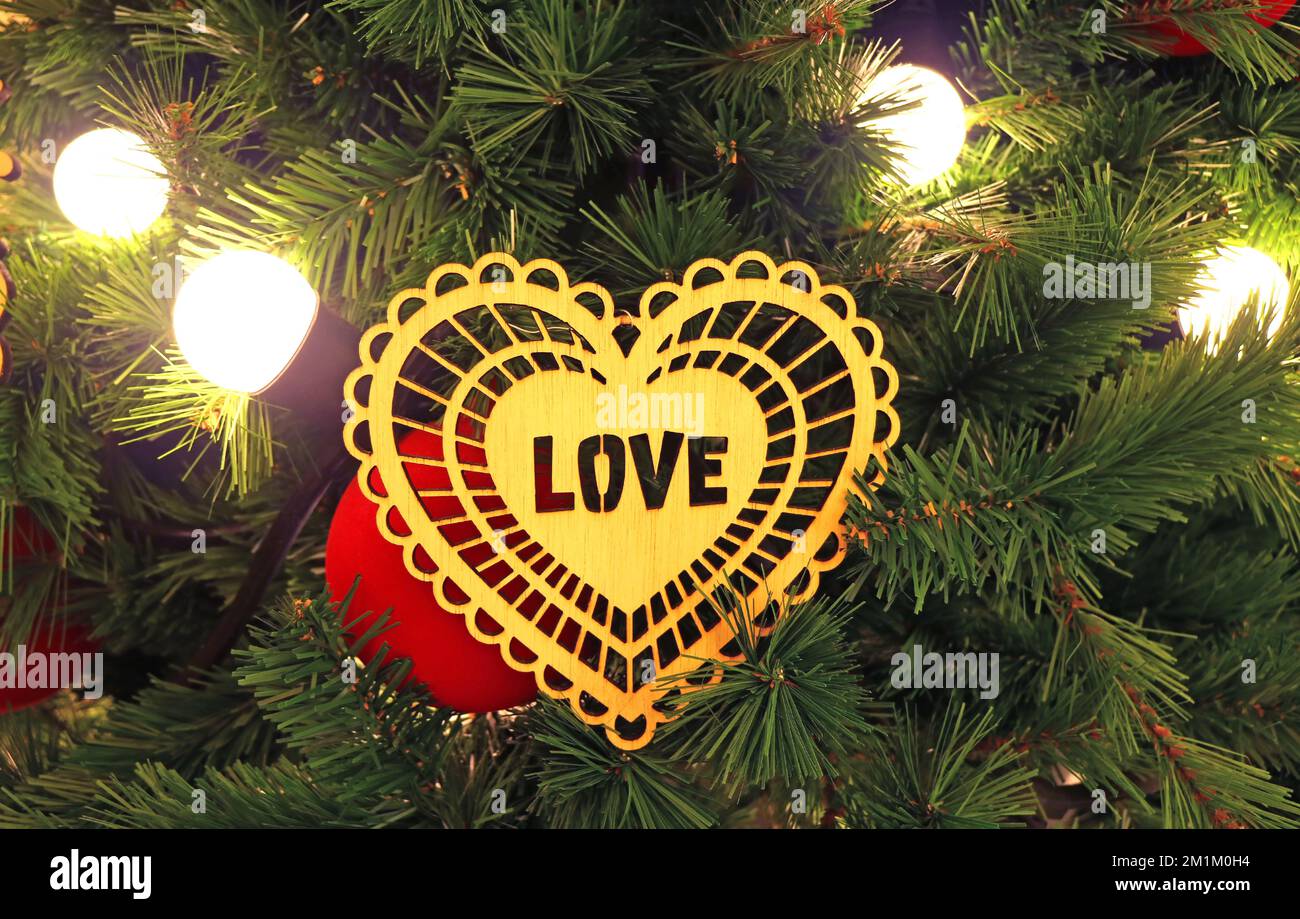 Gros plan de l'ornement en forme de coeur avec le texte AMOUR accroché sur le sapin de Noël Banque D'Images