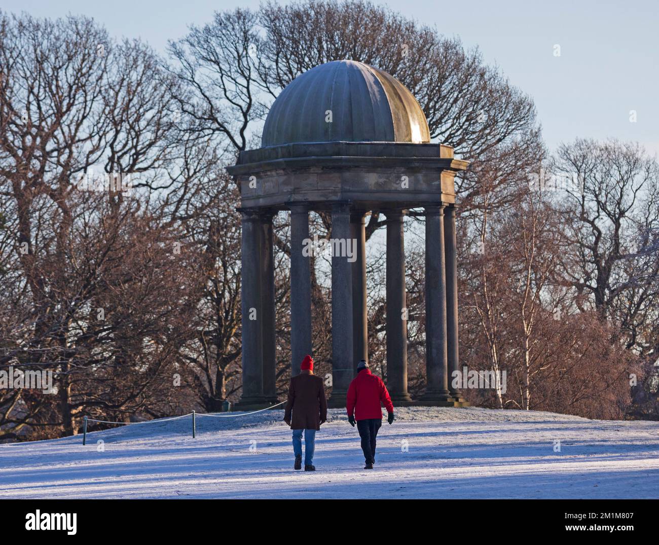 Édimbourg, Écosse, Royaume-Uni. 13th décembre 2022. Les résidents se sont réveillés jusqu'à geler moins 7 degrés centigrades dans la capitale écossaise, le gel intense hier et aujourd'hui faisant pour des conditions très verglacées. Deux mâles plus âgés font une promenade à travers le parcours de golf de Duddingston, autrement déserté, avec le monument en arrière-plan. Credit: ArchWhite/alamy Live news Banque D'Images