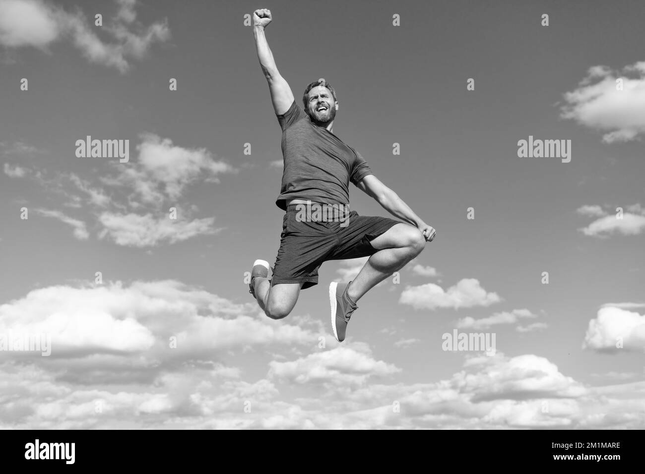 un homme musclé sautant dans des vêtements de sport en plein air sur fond de ciel, succès Banque D'Images